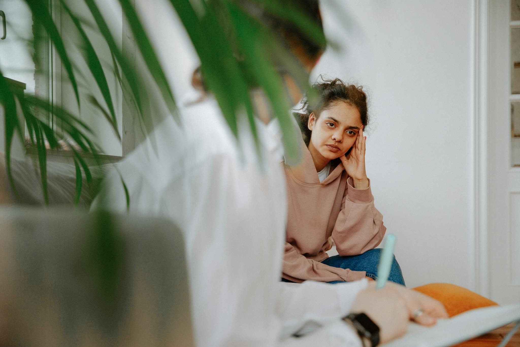 A woman in a therapy session, engaging in a thoughtful discussion with her therapist.